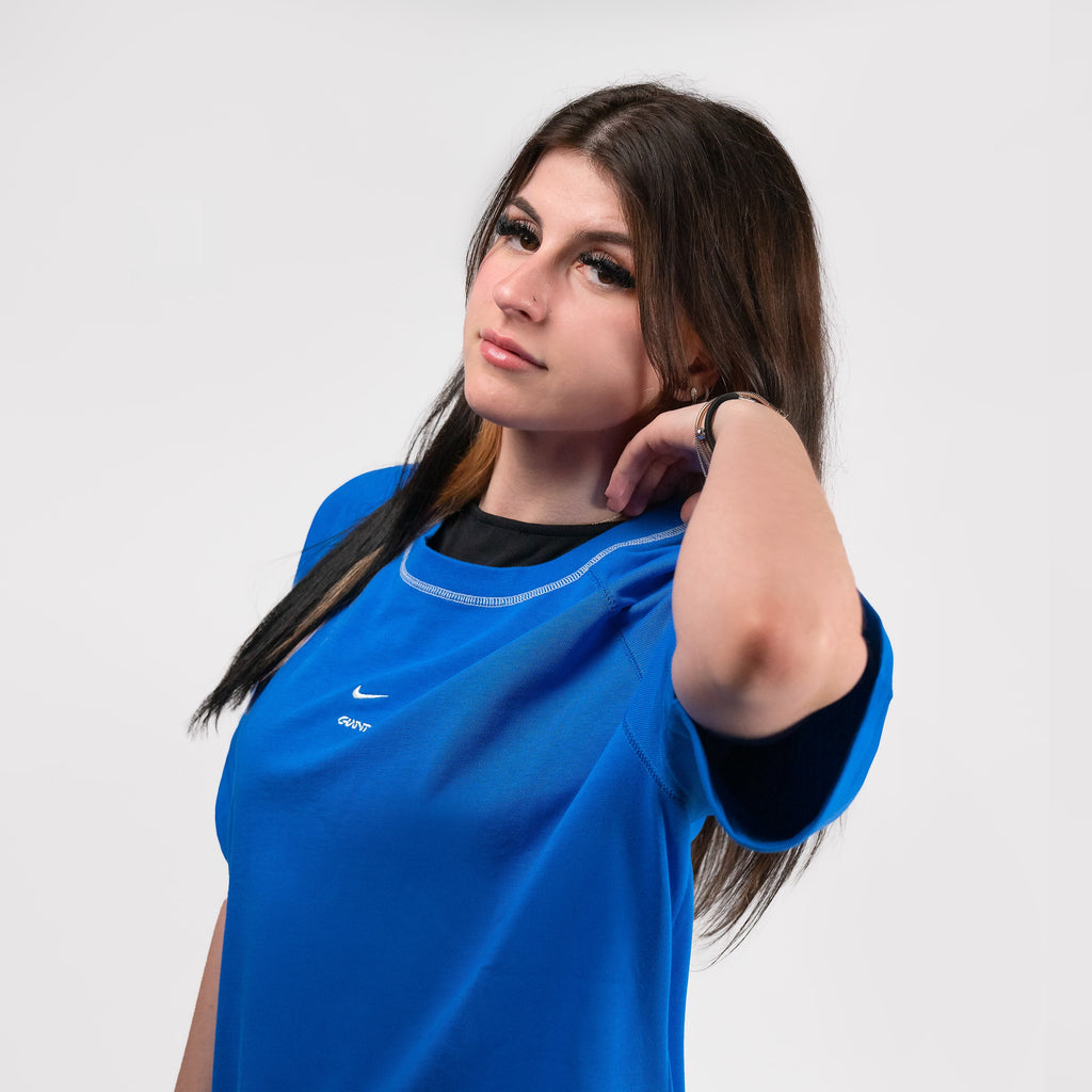 Camiseta Strike Giants x Nike, influencer Abby posando en un plano medio tocándose el pelo con la camiseta.